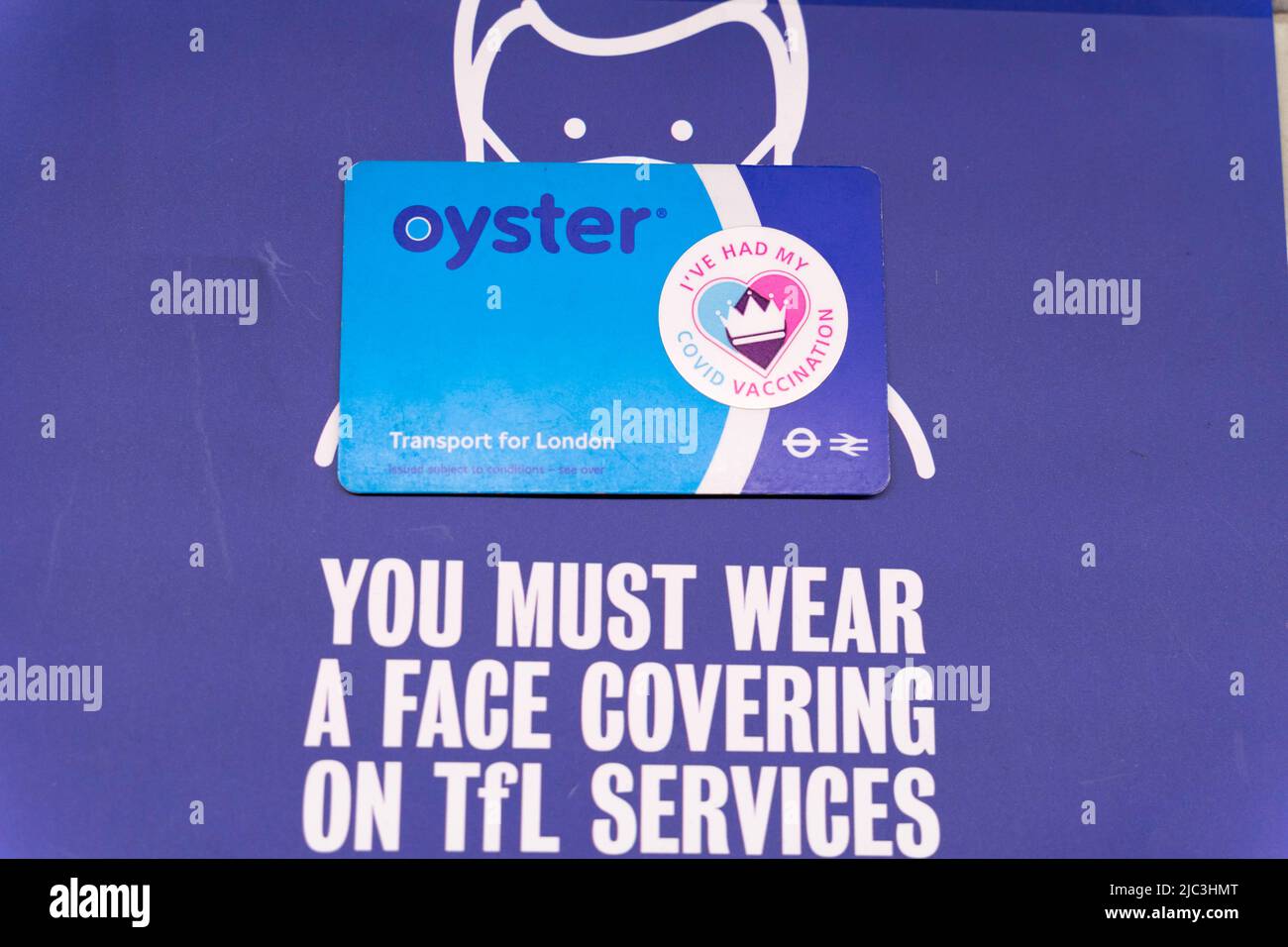 Schilder mit der Frage „Sie müssen eine Gesichtsabdeckung auf tfl-Diensten und -Stationen tragen“ in London Underground England Stockfoto