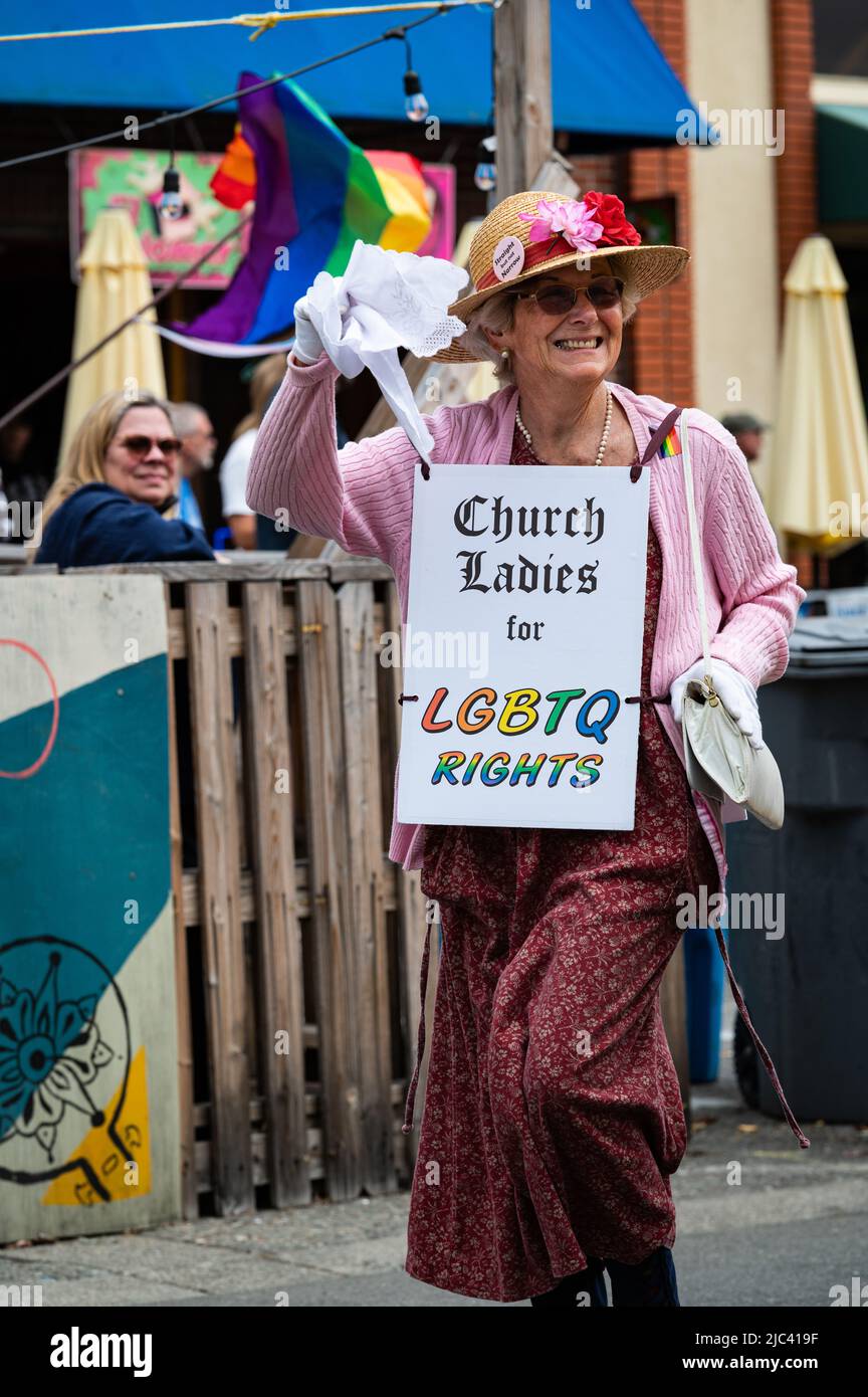 Foto einer älteren Frau, die ein Schild mit der Aufschrift "Church Ladies for LGBTQ Rights" trägt und im Rahmen der Sonoma County Pride Parade marschiert. Stockfoto