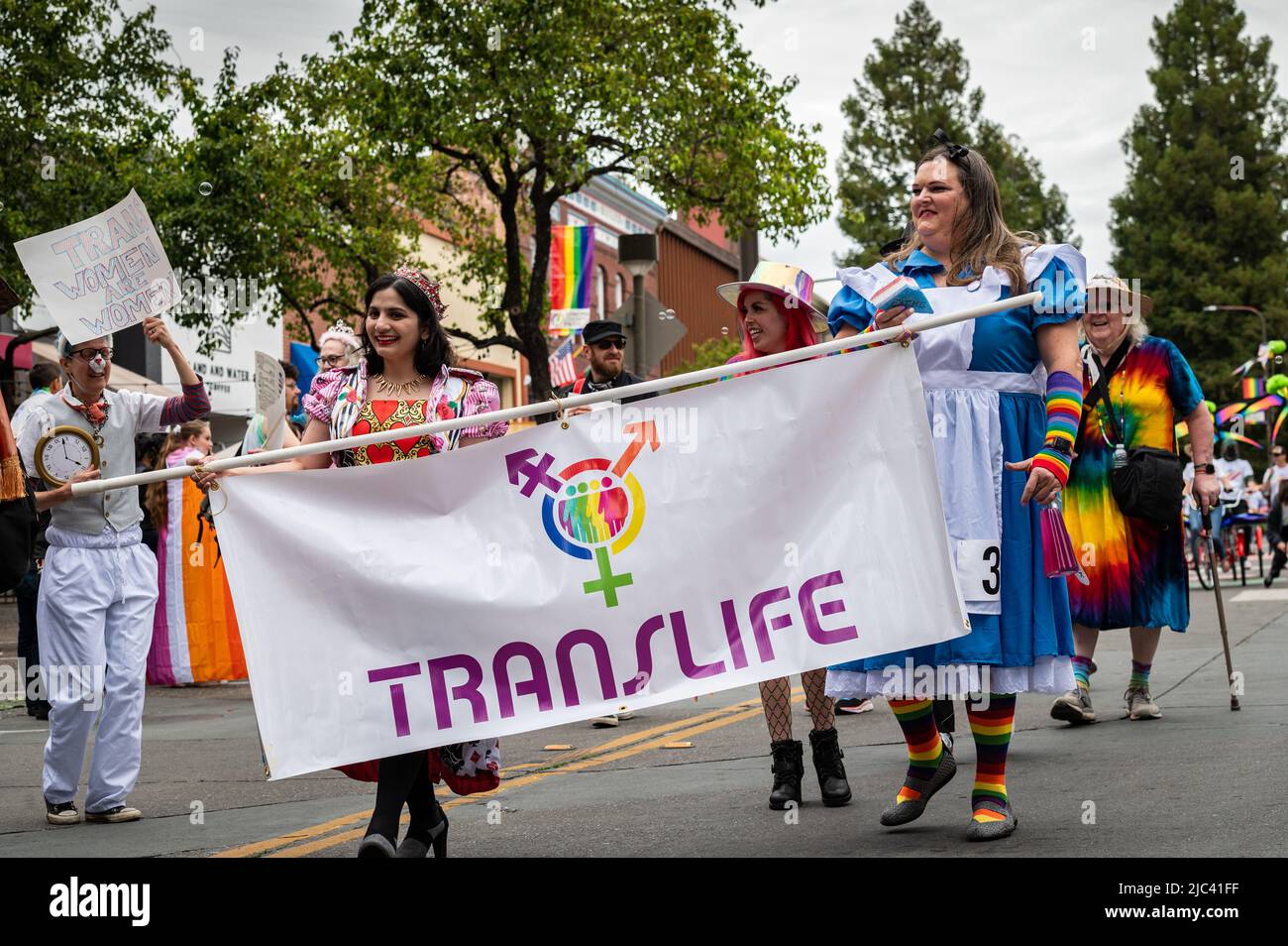 Foto des Translife-Eintritts für Sonoma County Pride, mit Menschen in bunten Kostümen, die das Banner halten. Stockfoto