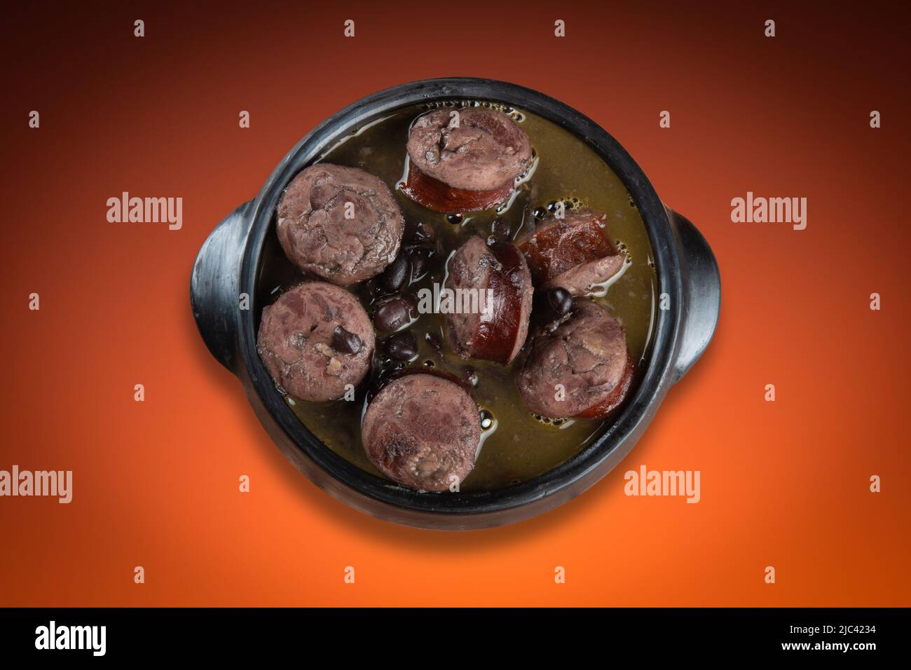 Feijoada in Keramik Topf mit Farbverlauf Hintergrund. Stockfoto