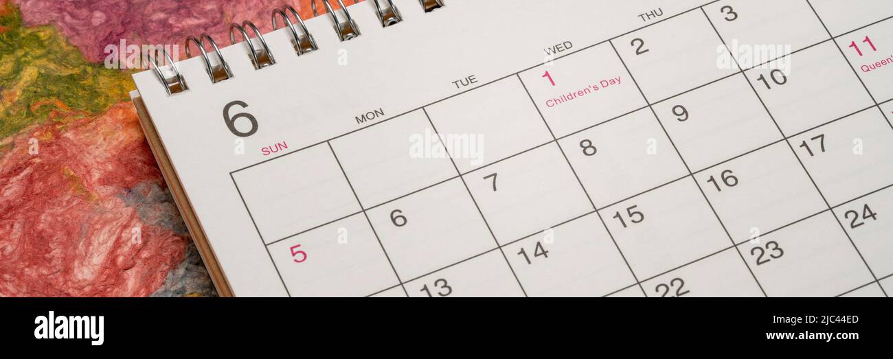Juni - Detail eines Spiral-Desktop-Kalenders gegen knalliges, farbenprächtiges Papier, Zeit- und Geschäftskonzept Stockfoto