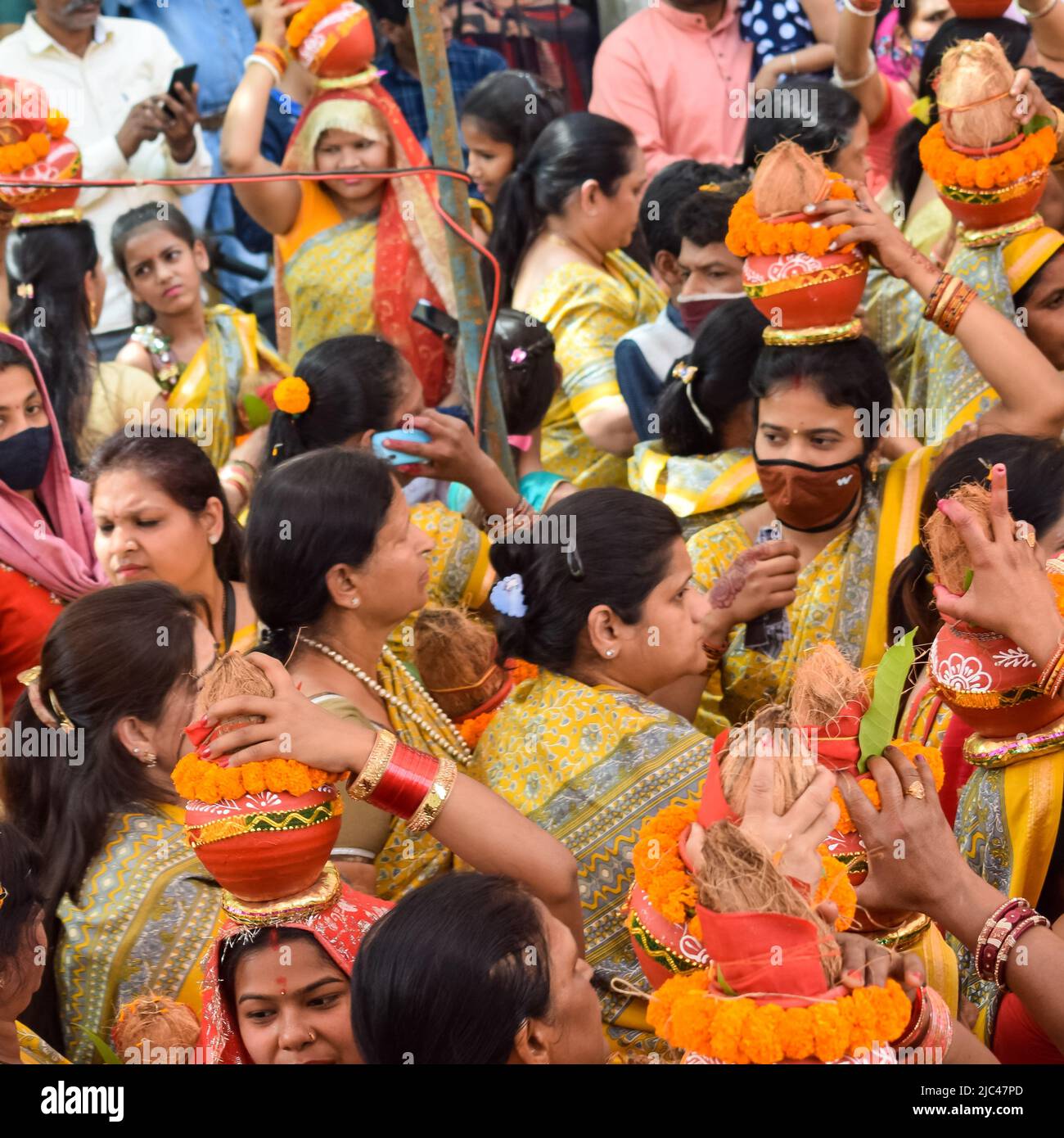 Neu Delhi, Indien April 03 2022 - Frauen mit Kalash am Kopf während des Jagannath-Tempels Mangal Kalash Yatra tragen indische Hindu-Anhänger irdische Töpfe Conta Stockfoto