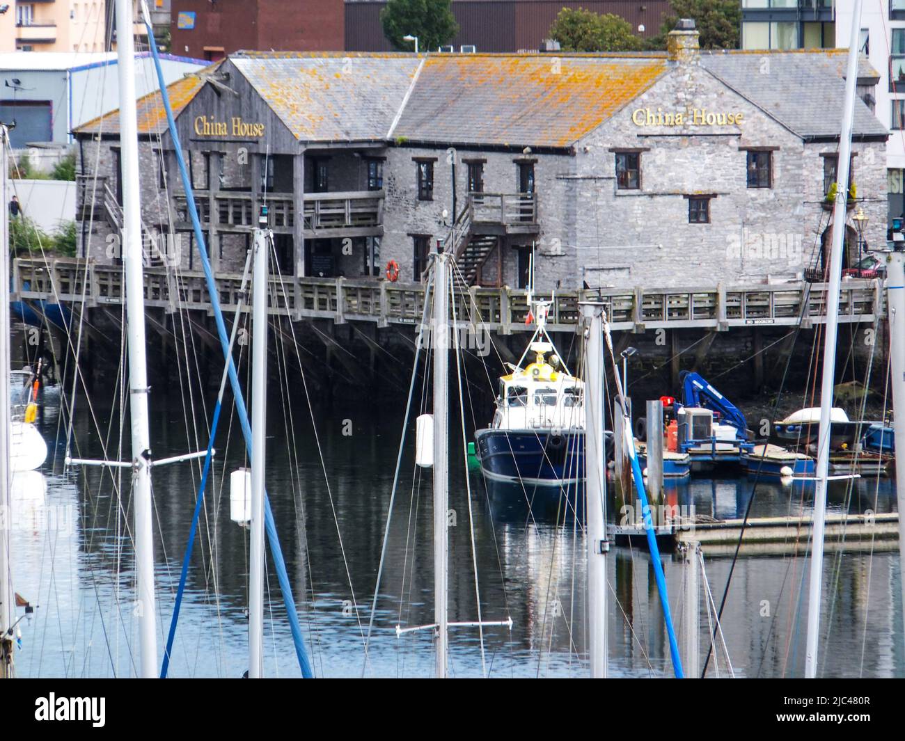 Das ehemalige China House Restaurant in Coxside, Plymouth, England, ist durch die Masten der Segelboote am Sutton Harbour zu sehen. Stockfoto