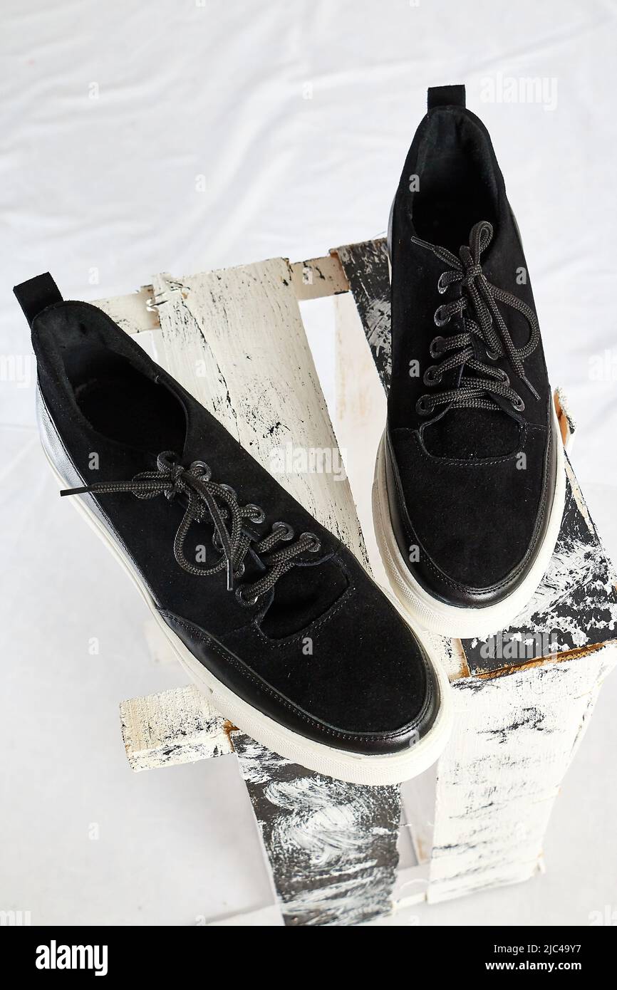 Modische Sneakers aus Wildleder. Sportschuhe. Teure Schuhe oder Slipper isoliert auf weißem Hintergrund mit anderen Dingen. Professionelles Fotoshooting Stockfoto