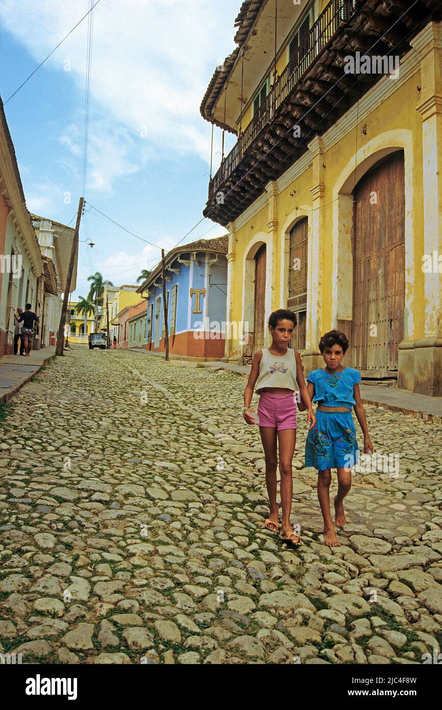 Zwei junge Mädchen, die auf einer Gasse mit Kopfsteinpflaster spazieren, Trinidad, UNESCO-Weltkulturerbe, Kuba, Karibik Stockfoto