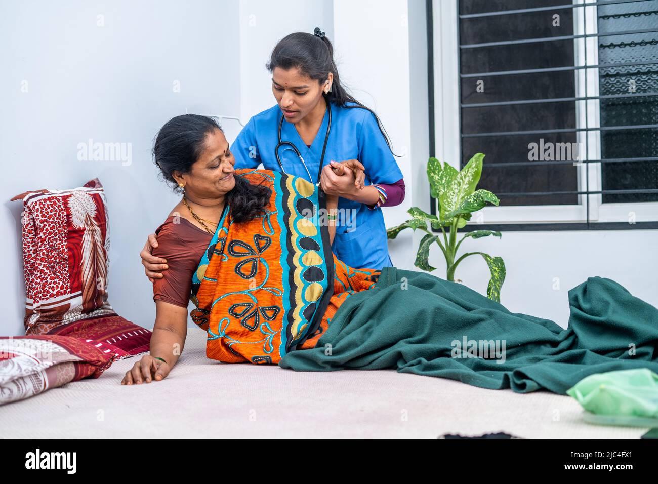 Krankenschwester, die kranken älteren Frauen hilft, während der Tagesbetreuung vom Bett aufzustehen - Konzept des beruflichen Berufs, häuslicher Gesundheitsversorgung oder medizinischen Dienstes Stockfoto