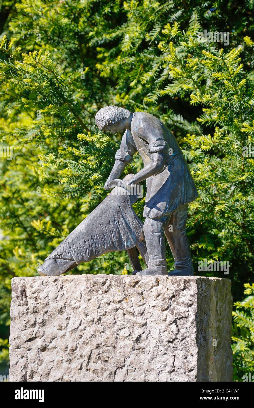 Pfullinger Handwerksbrunnen, Gerber bei der Arbeit, Abkratzen von Tierhaut, Lederverarbeitung, Denkmal für ausgestorbene Berufe, Schloesslepark Stockfoto