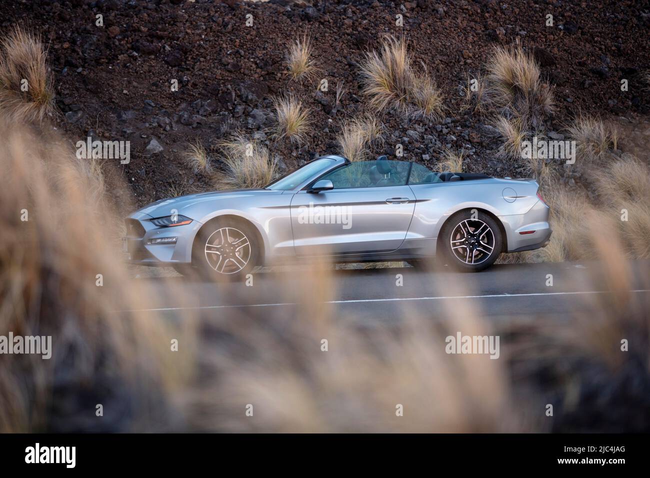 Ford Mustang Cabrio, Mietwagen am Straßenrand, umgeben von schwarzer Lava, Kona, Big Island, Hawaii, USA Stockfoto