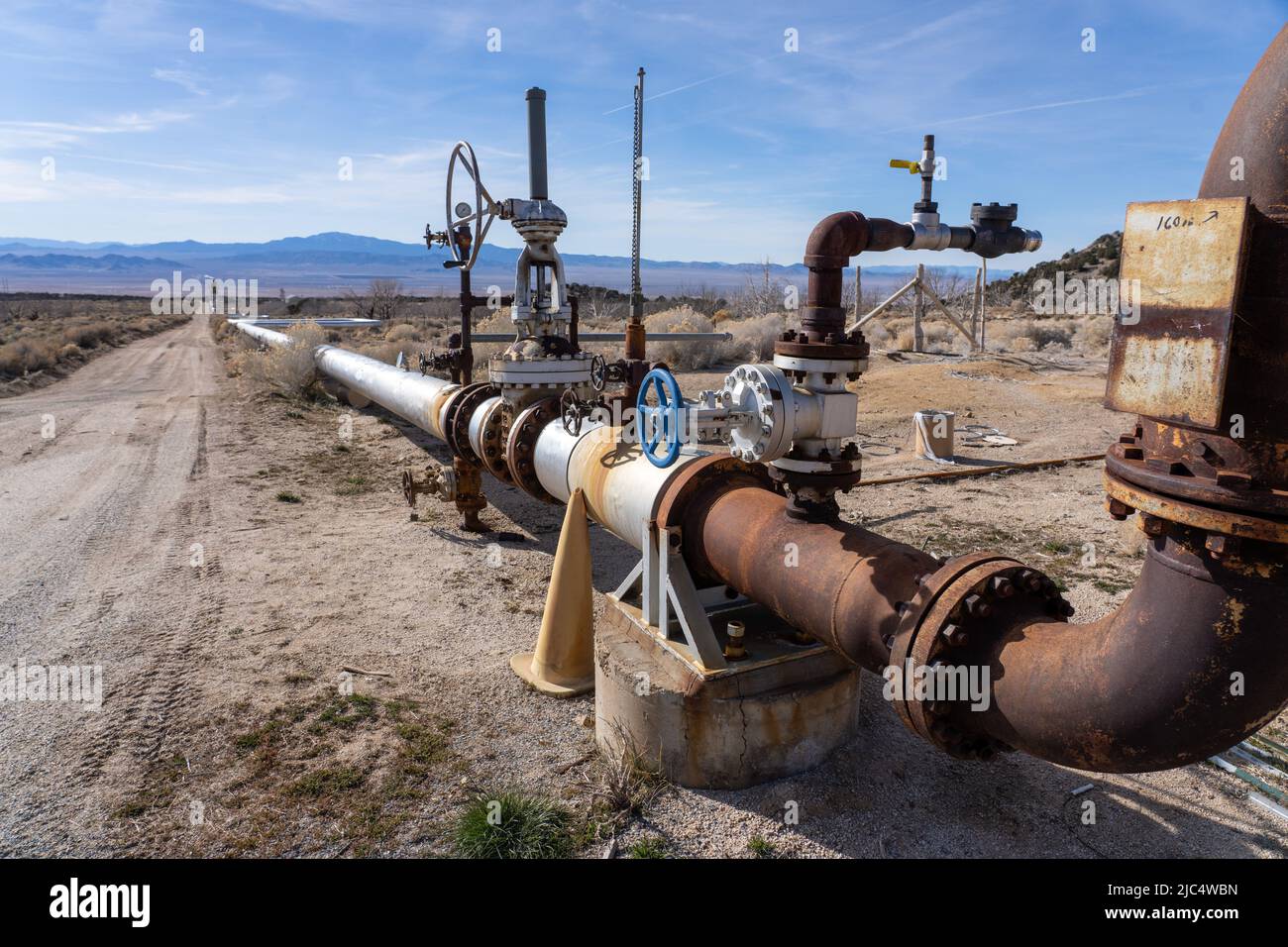 Rohrleitungen für eine geothermische Injektionsbohrung, die gekühltes Wasser aus dem Geothermiekraftwerk Blundell zurückgibt. Stockfoto