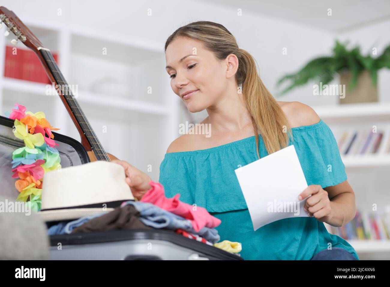 Frau packen ihre Koffer im Wohnzimmer Stockfoto
