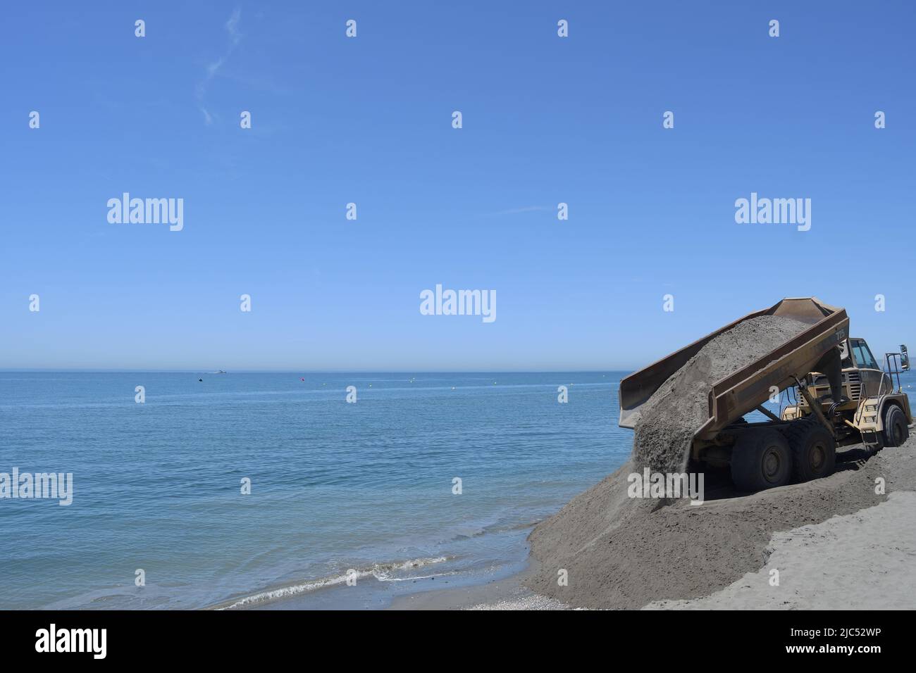 LKW entladen Sand zusammen einen Strand. Strände Generationen arbeiten Stockfoto