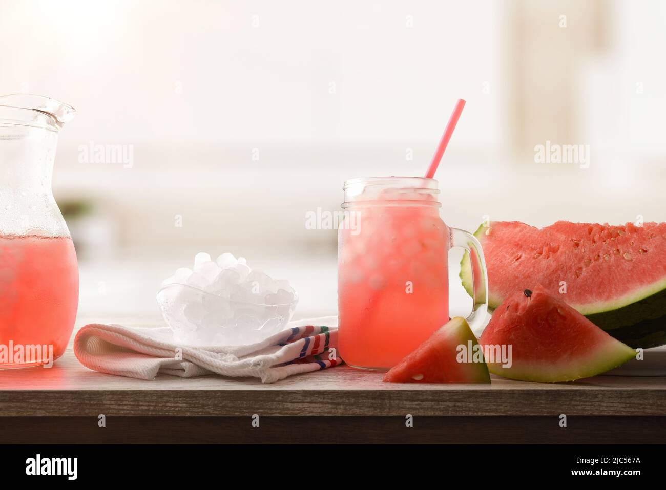 In einer Schüssel auf einem Holztisch in einer Küche Wassermelonen-Slush mit geschnittenem Obst und zerkleinertem Eis. Vorderansicht. Horizontale Zusammensetzung. Stockfoto
