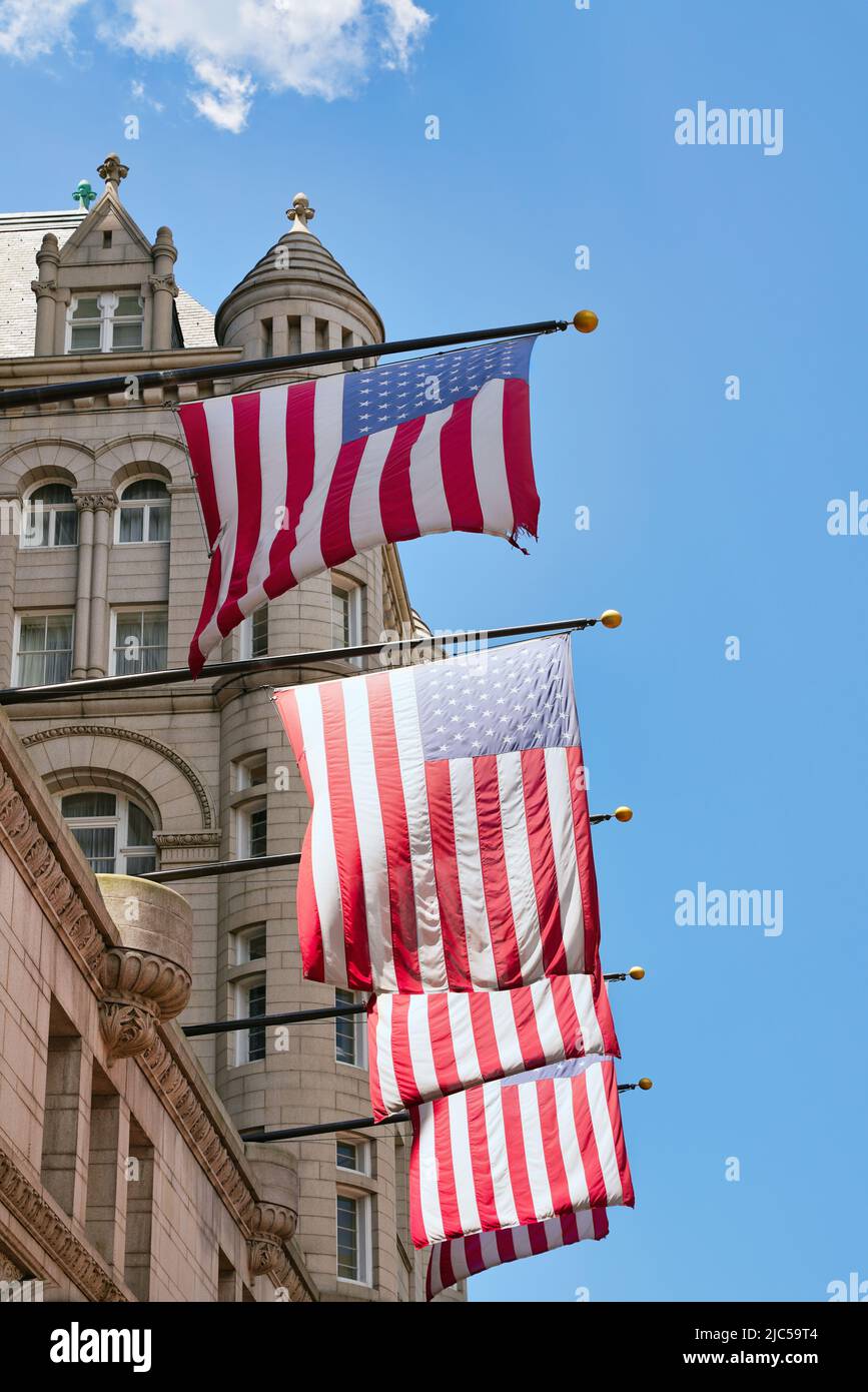 US-Flaggen auf dem alten Postgebäude in Washington, D.C., USA. US-amerikanische Flaggen mit Sternen und Streifen im Sonnenlicht. Stockfoto