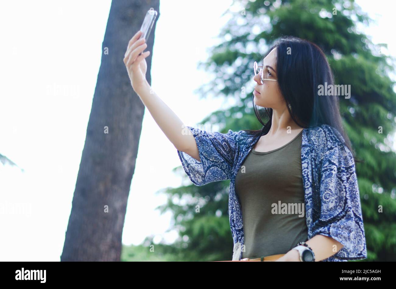Porträt einer jungen glücklichen Geschäftsfrau, die sich in der Stadt entspannt, Park an der Adria. Über Telefon. Selfie.-Technologie. Soziale Medien. Videoanruf. Sommer Stockfoto
