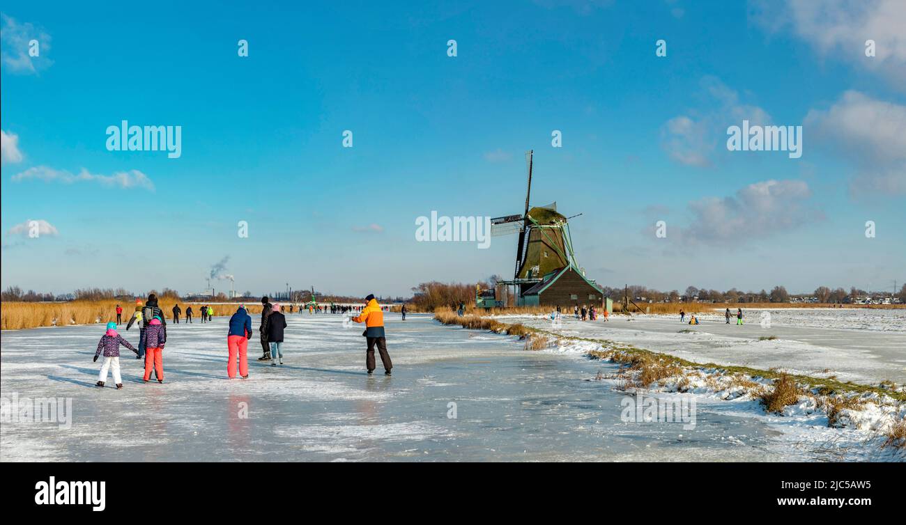 Scating auf einem gefrorenen Kanal in der Nähe einer Windmühle *** Local Caption *** Niederlande, Windmühle, Wasser, Winter, Schnee, Eis, Menschen, Scaters, ,Westzaan, Noord- Stockfoto