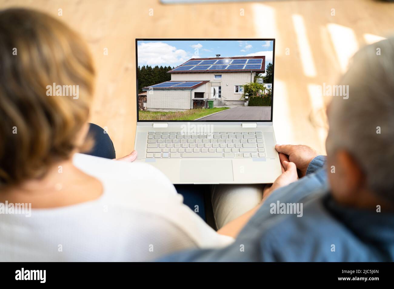 Paar an Haus Online auf Laptop zu Hause Suchen Stockfoto
