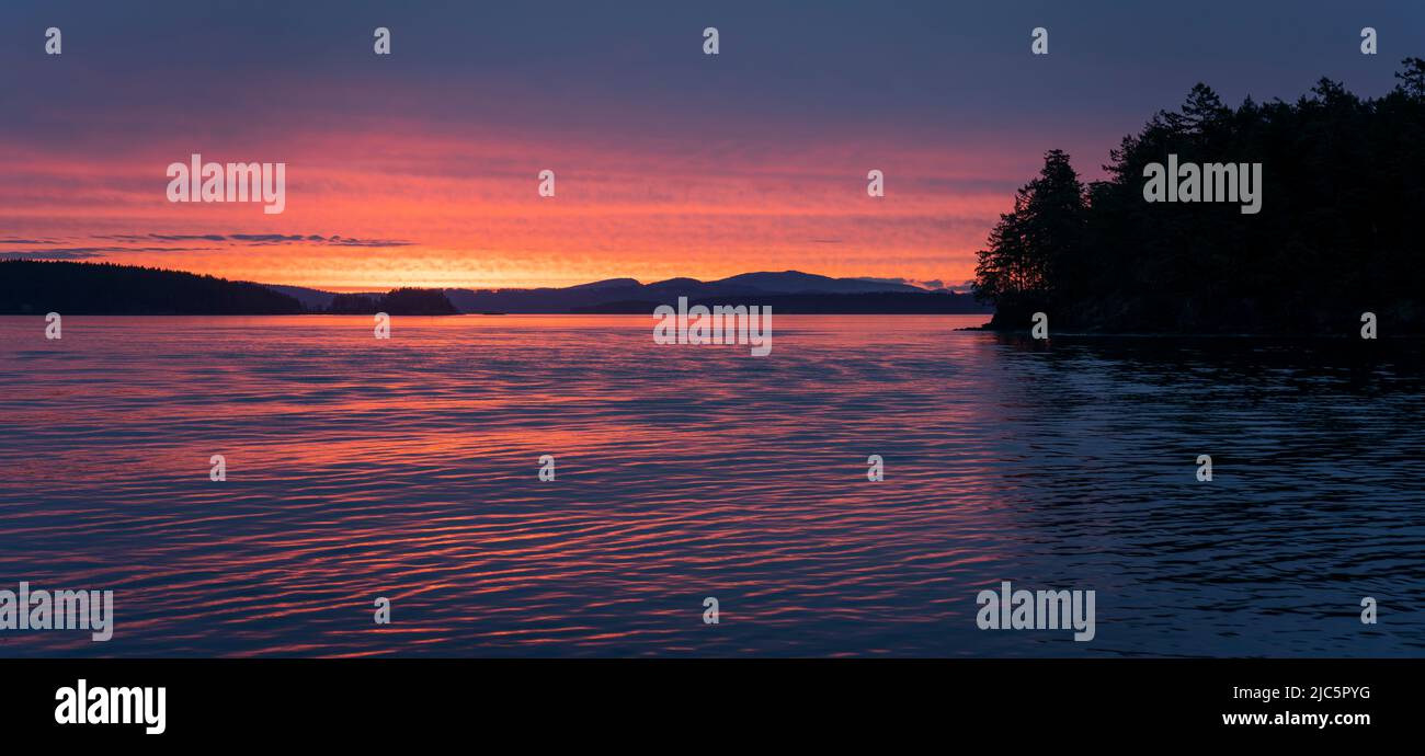 Sonnenaufgang über dem Salish Meer, von einer Fähre aus gesehen, die durch die südlichen Golfinseln von British Columbia, Kanada, fährt. Stockfoto
