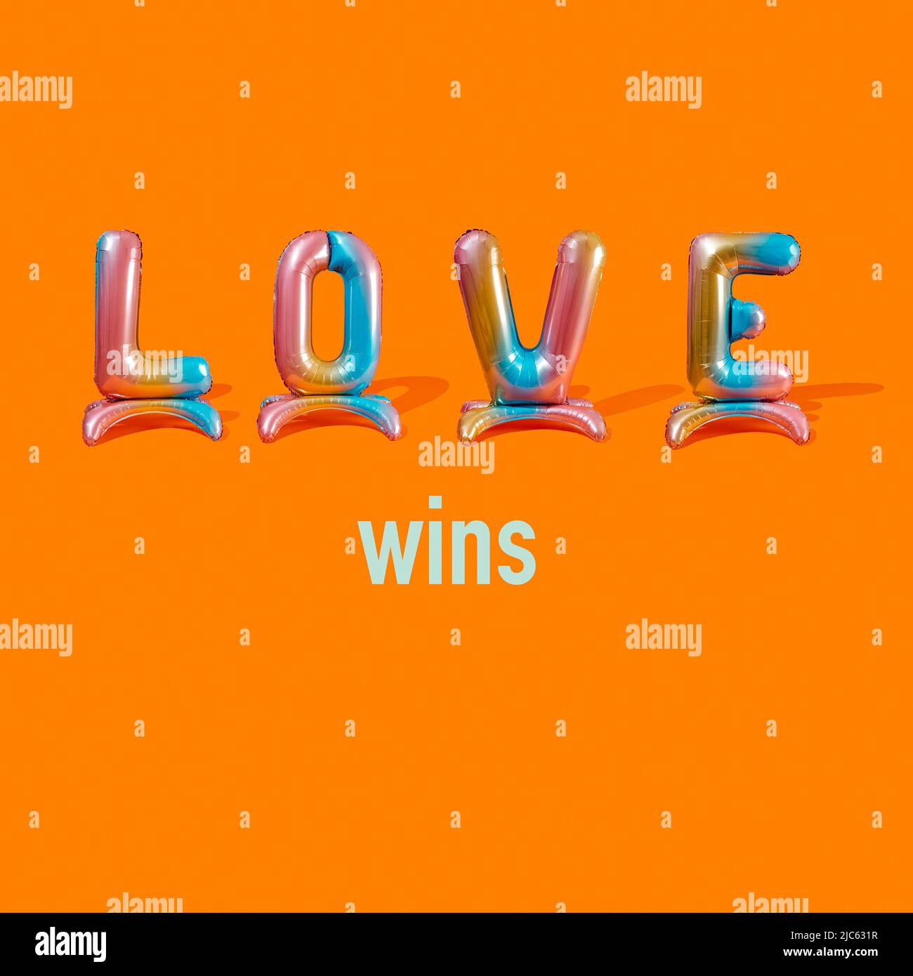 Text Love gewinnt auf einem orangefarbenen Hintergrund, mit dem Wort Love aus vier bunten, buchstabenförmigen Ballons Stockfoto