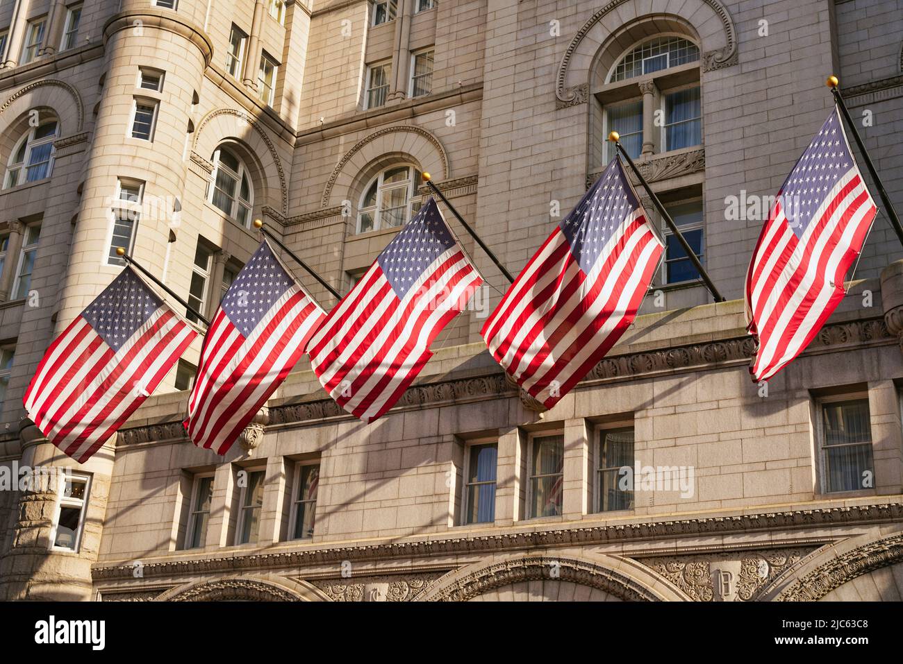US-Flaggen auf dem alten Postgebäude in Washington, D.C., USA. US-amerikanische Flaggen mit Sternen und Streifen im Sonnenlicht. Stockfoto