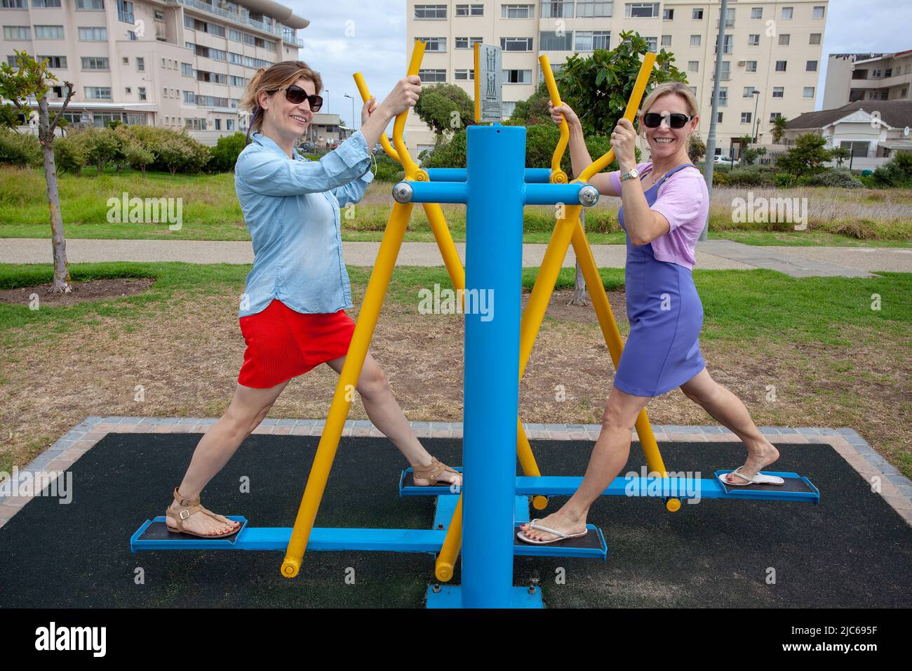 Outdoor-Fitness & Freundschaft: Zwei Frauen genießen ein zwangloses Workout Stockfoto