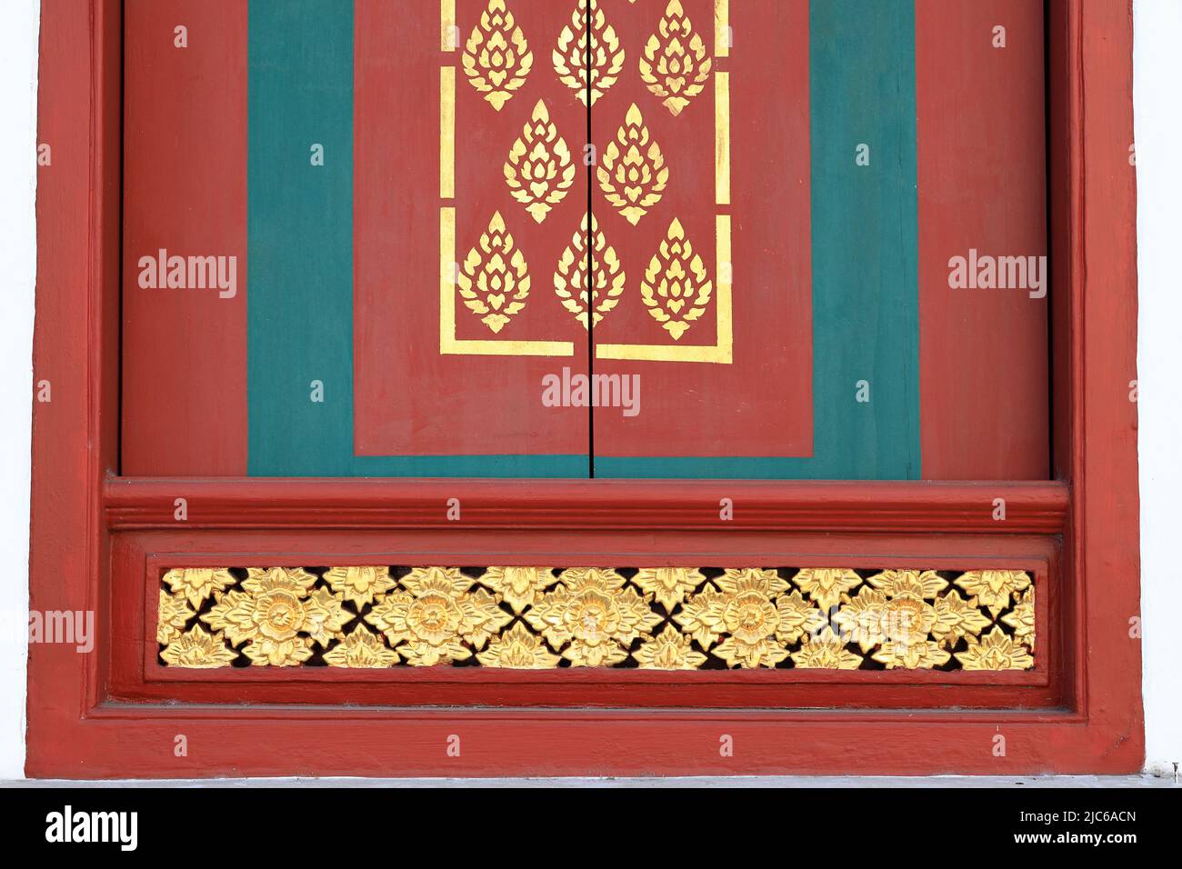 Wunderschönes Muster traditioneller thailändischer Kunst, verziert aus Spiegelfliesen an einer Tür eines öffentlichen buddhistischen Tempels, Texturen im Hintergrund Stockfoto