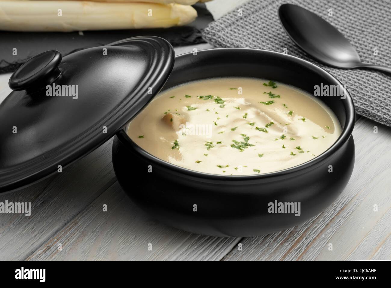 Köstliche weiße Spargelcremesuppe auf Holzboden Stockfoto