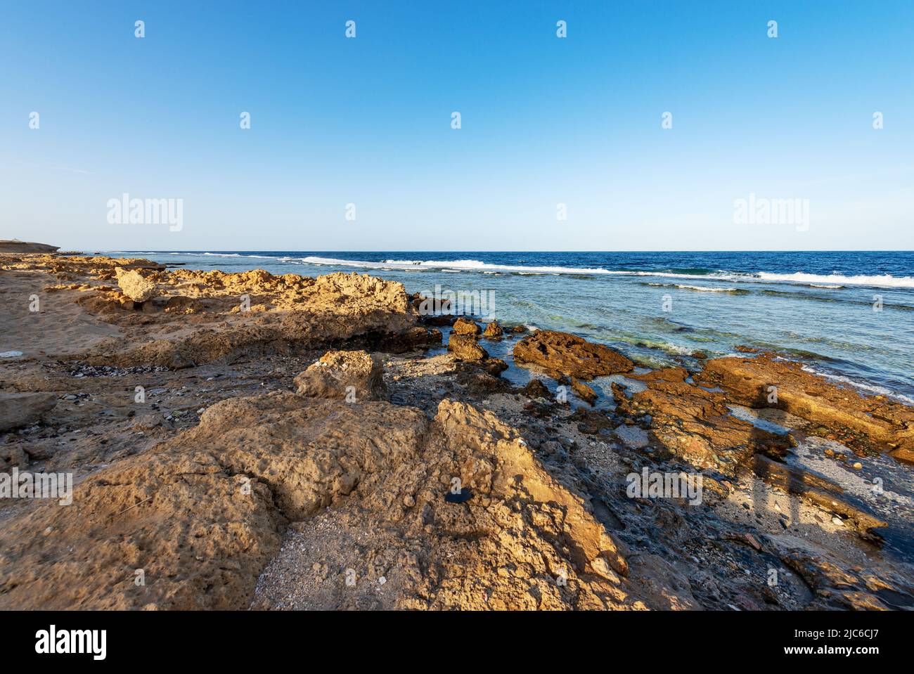 Schöne Meereslandschaft des Roten Meeres in der Nähe von Marsa Alam, Ägypten, Afrika. Die Wellen brechen auf dem Korallenriff und der Klippe. Stockfoto