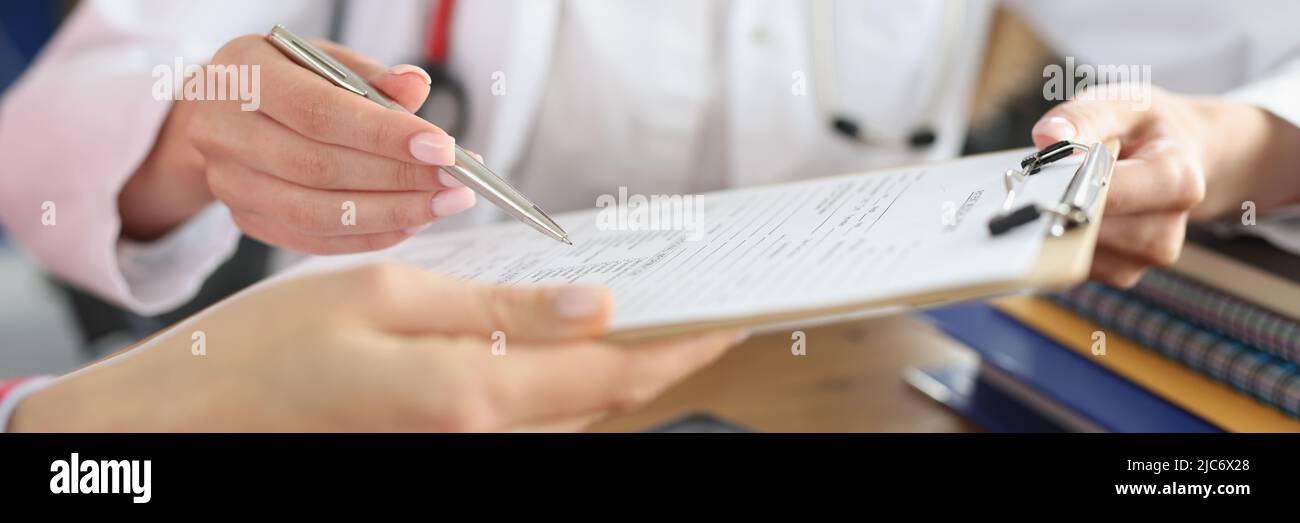 Ärztin und Patientin, die einen medizinischen Vertrag unterzeichnet Stockfoto