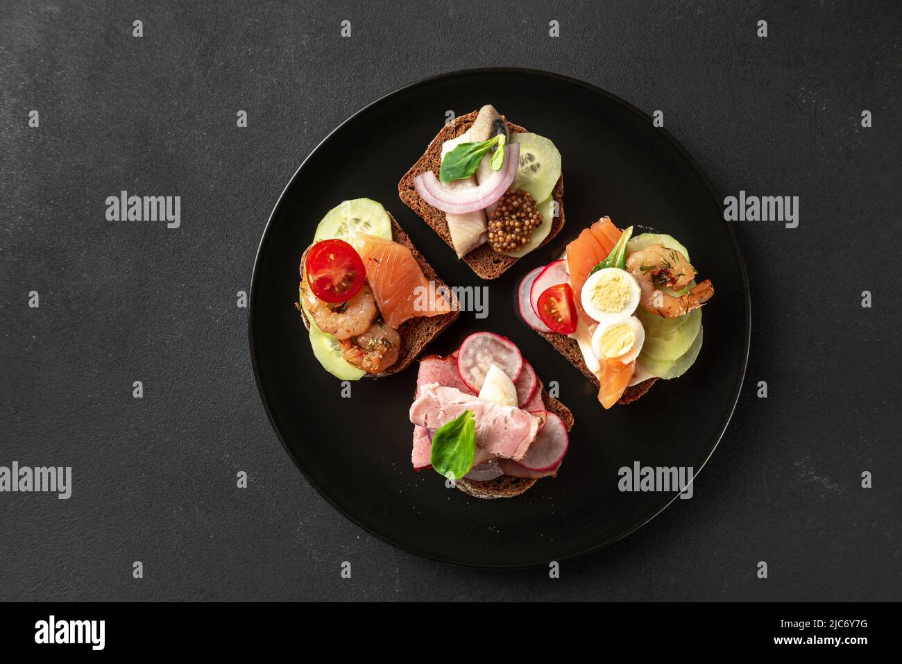 Dänische Sandwiches auf einem schwarzen Teller, Draufsicht Stockfoto