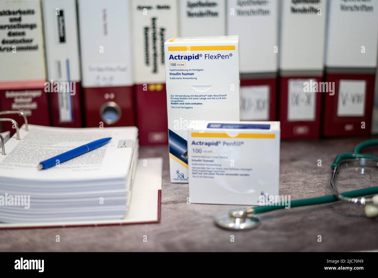 Medikament Actrapid mit humanem Insulin zur Behandlung von Diabetes. Auf einem Tisch und im Hintergrund verschiedene medizinische Bücher. Stockfoto