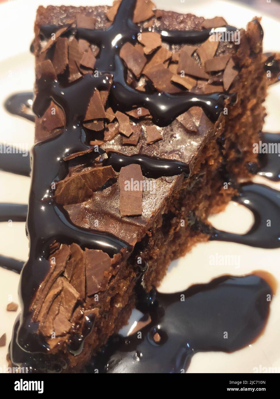 Nahaufnahme von köstlichem Schokoladenkuchen, der auf einem Teller mit Schokoladensirup serviert wird Stockfoto