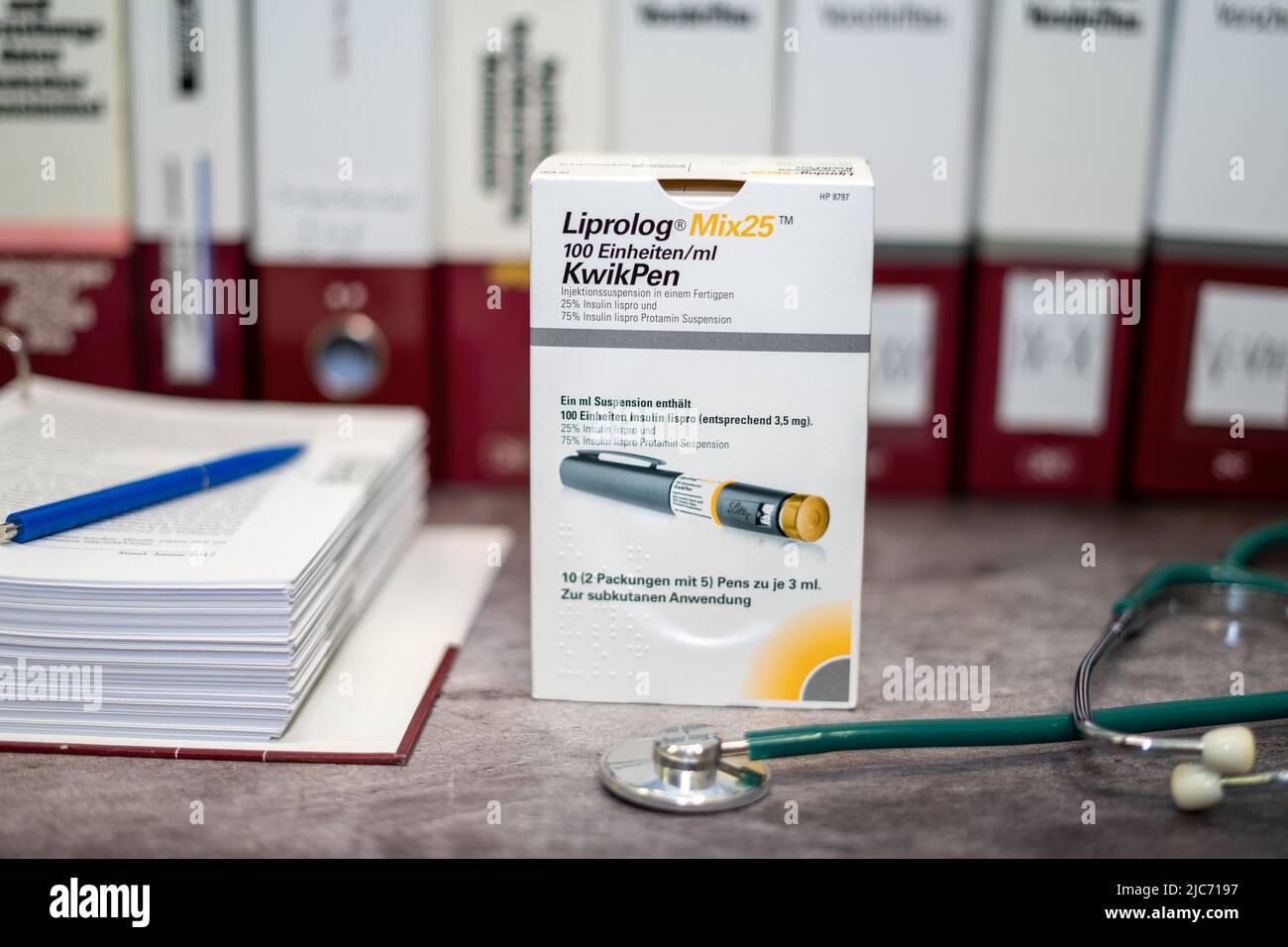 Medikament Liprolog, das Insulin-Lispro für Diabetes mellitus enthält, auf einem Tisch und im Hintergrund verschiedene medizinische Bücher. Stockfoto