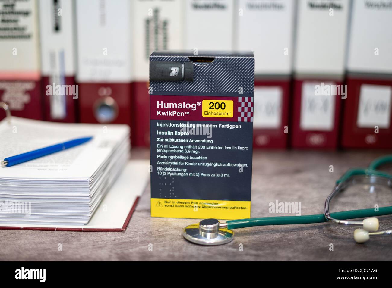 Eine Drug Box Humalog, die lang wirkendes Insulin zur Behandlung von  Diabetes enthlt, auf einem Tisch und im Hintergrund verschiedene  medizinische Bcher Stockfotografie - Alamy