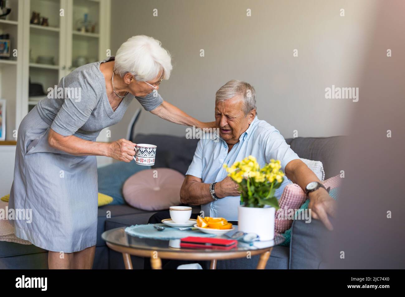 Besorgte ältere Frau, die ihren Mann tröstet, der Schmerzen hat Stockfoto