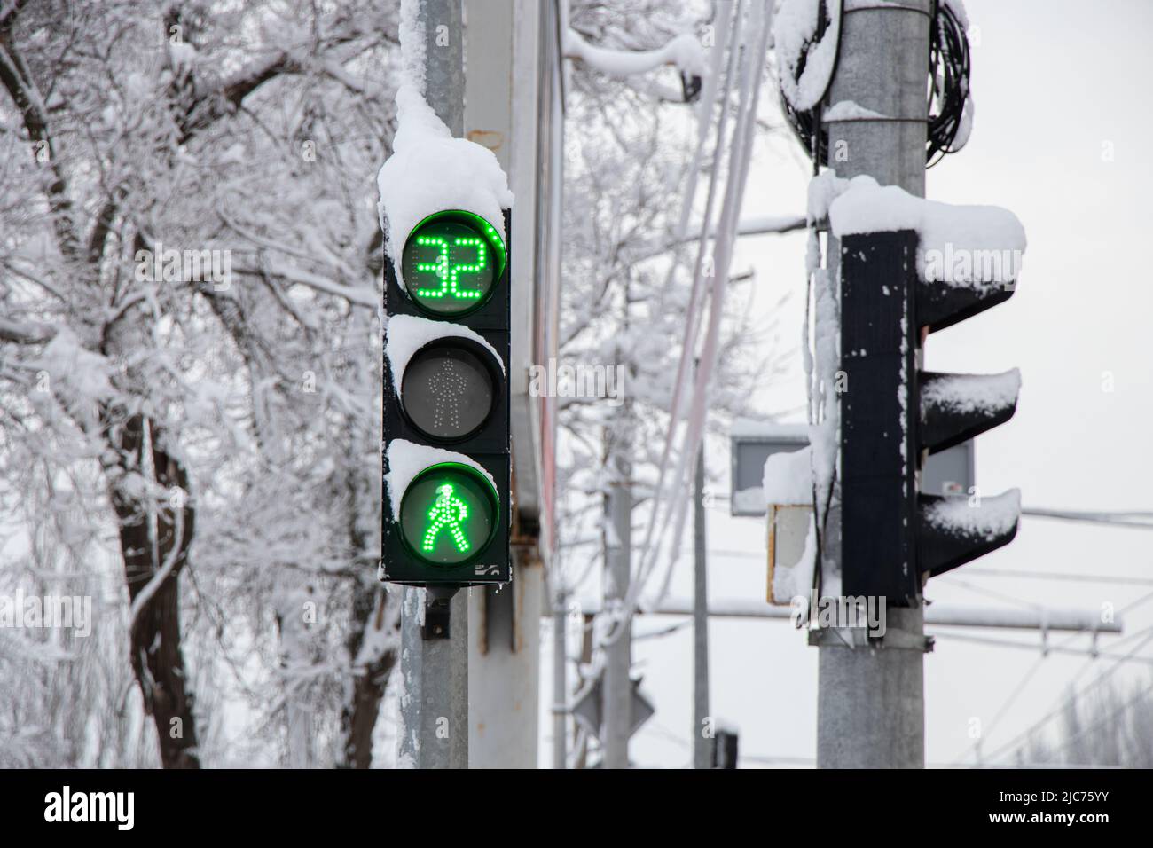 Eine grüne Ampel im Winter in Schnee und Eis in der Ukraine in der Stadt Dnipro wurden Straßen angehoben, eine Ampel in der Stadt Stockfoto