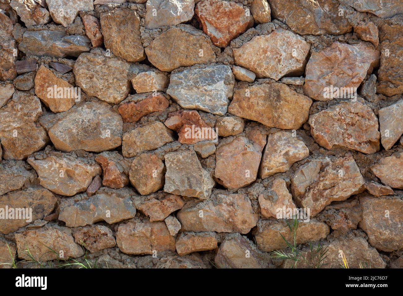 Alte raue Steinmauer Hintergrund. Dorfhaus Steinmauer. Vorderansicht. Stockfoto