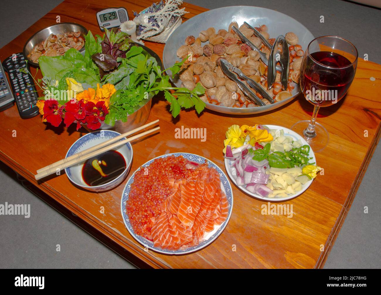 Leben in Neuseeland. Angeln, Nahrungssuche, Tauchen, Gartenarbeit, Weinherstellung und Sport. Ein Fest mit wildgefangenem Sashimi-Lachs, Nüssen und Salat. Stockfoto