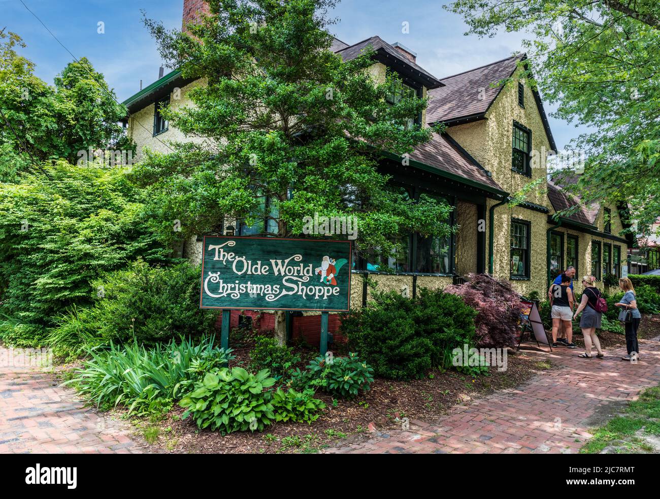 BILTMORE VILLAGE in ASHEVILLE, NC, USA-5 JUNE 2022: The Olde World Christmas Shoppe, Building and sign, with 4 people at entrance. Stockfoto