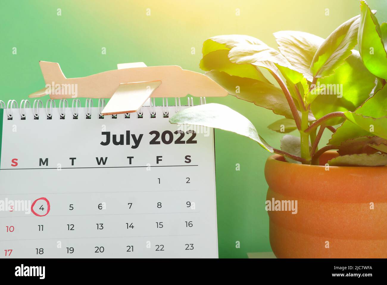 Selektiver Fokus des Tischkalenders Juli 2022 mit markierter Datumsangabe 4.. Juli und Flugzeugmodell. United States Independence Day Feier und Feiertag Stockfoto