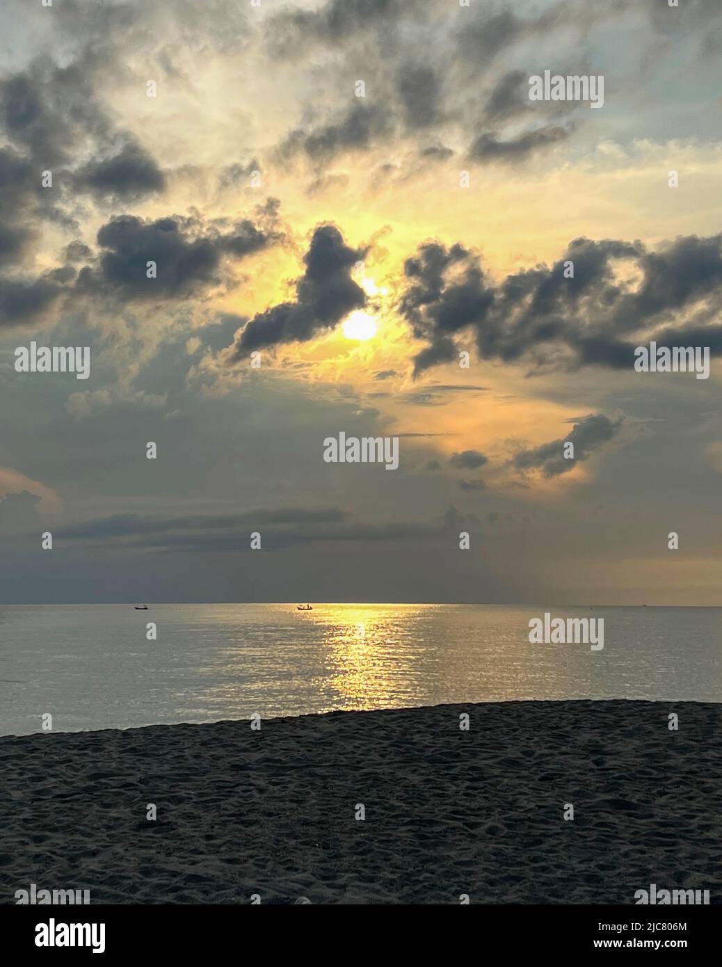 Zwei Fischerboote segeln im Meer, Fischer segeln ihre Boote und fischen unter dem surise Himmel mit dunkler Wolke Stockfoto