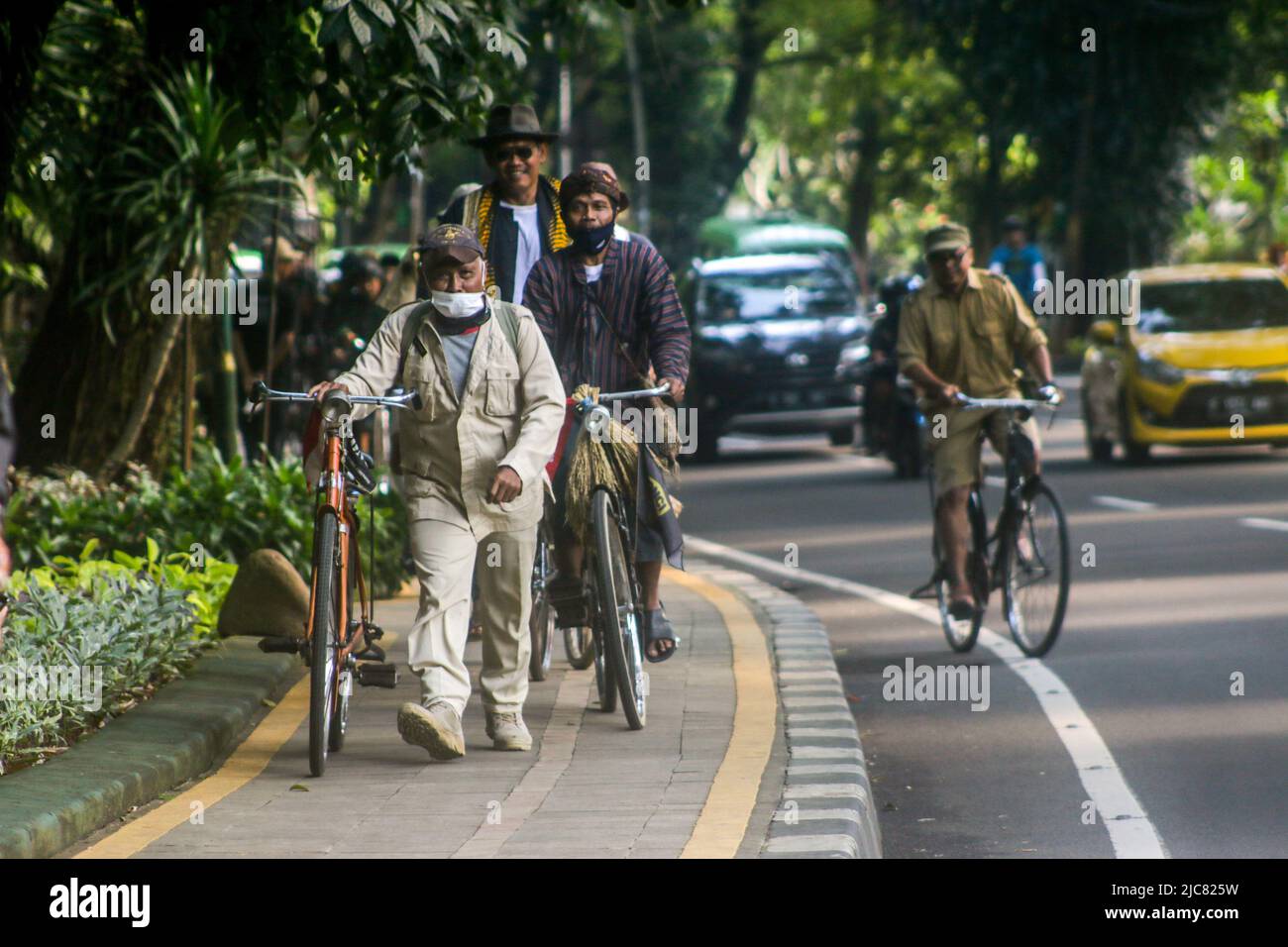 Mitglieder der Onthel Community fahren gemeinsam mit der Indonesischen Old Bike Community um die Stadt, um den Weltfahrradtag zu feiern Stockfoto