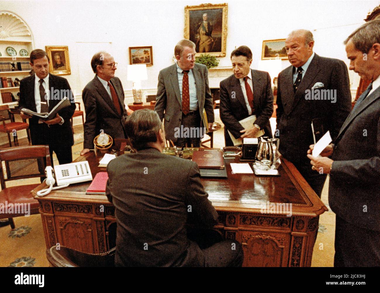 25. Oktober 1985, Washington, District of Columbia, USA: Auf diesem Foto, das vom Weißen Haus veröffentlicht wurde, hat der US-Präsident Ronald Reagan während eines Treffens mit leitenden Mitarbeitern bezüglich Grenada im Oval Office des Weißen Hauses in Washington, DC am 25. Oktober 1983. Bild vor dem Präsidenten, von links nach rechts: Der ehemalige US-Botschafter in Brasilien, Langhorne Motley, der stellvertretende Stabschef des Weißen Hauses, Michael Deaver, der Berater des Präsidenten Edwin Meese, der US-Verteidigungsminister Caspar Weinberger, der US-Außenminister George P. Shultz und der US-Sicherheitsberater Robert McFarlane.Ma Stockfoto