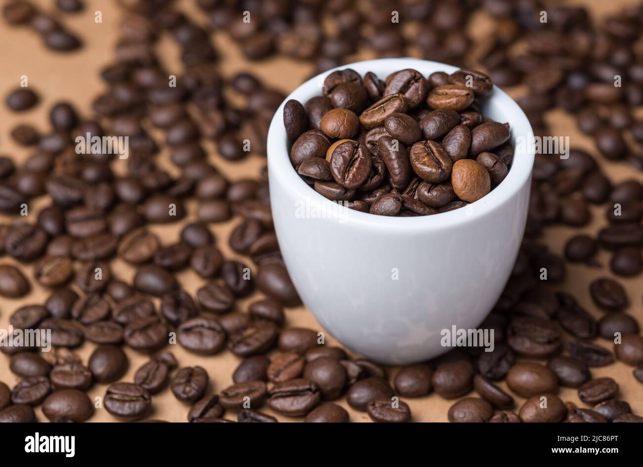 Geröstete Espresso-Kaffeebohnen und eine weiße Tasse Stockfoto