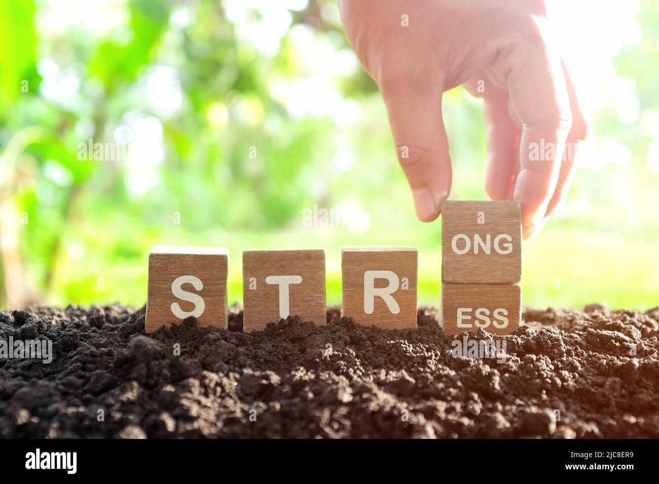 Starkes Stressmanagement-Konzept. Die Hand ändert den Stress zu einem starken Wort auf Holzblöcken. Stockfoto