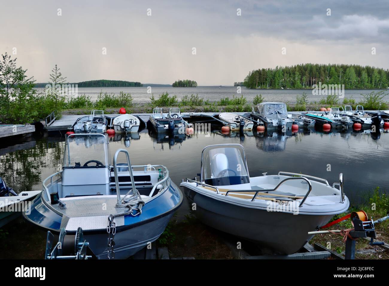 Boote von Menschen mit Sommerhäusern in der Nähe der Grenzzone am Pyhäjärvi-See auf der finnischen Seite des Finnland-Russland-borden Stockfoto