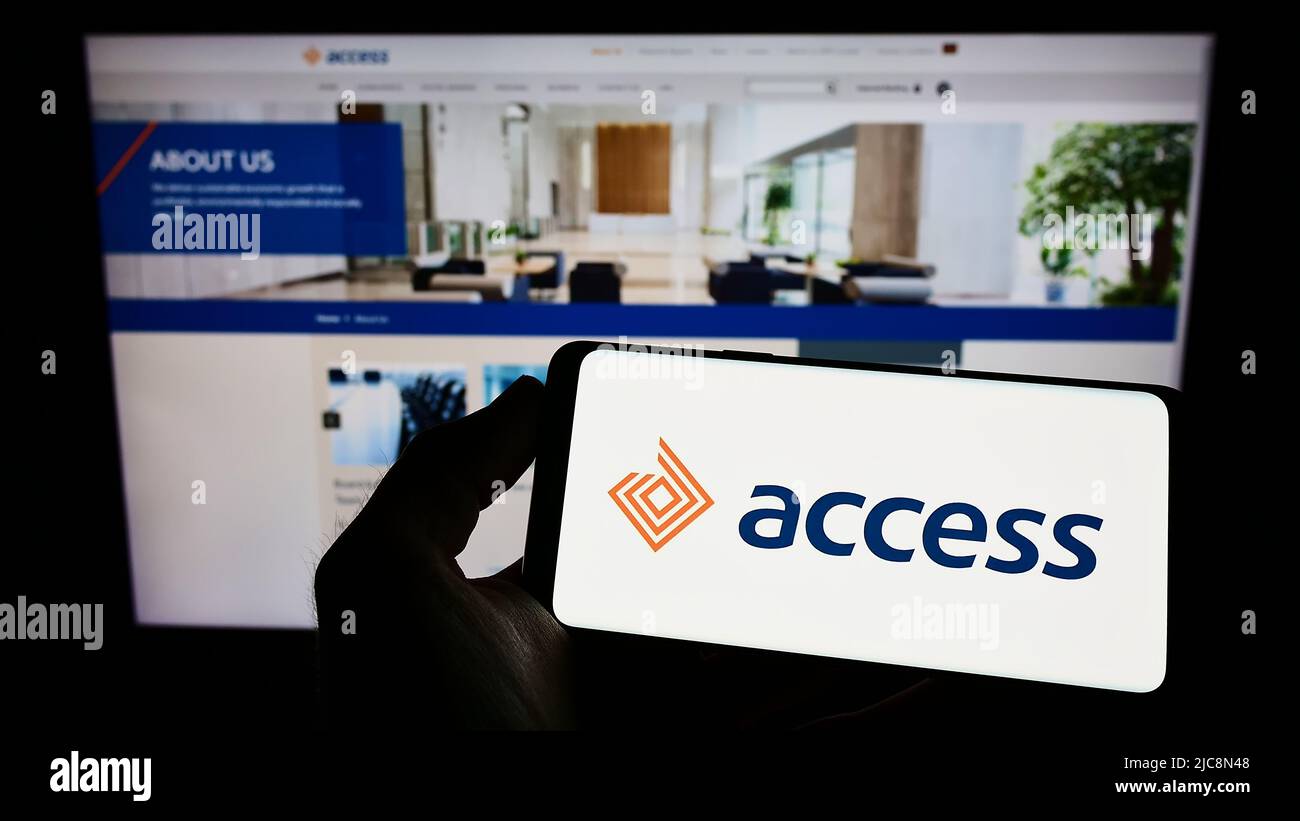 Person, die das Smartphone mit dem Logo des kenianischen Finanzunternehmens Access Bank Plc auf dem Bildschirm vor der Website hält. Konzentrieren Sie sich auf die Telefonanzeige. Stockfoto