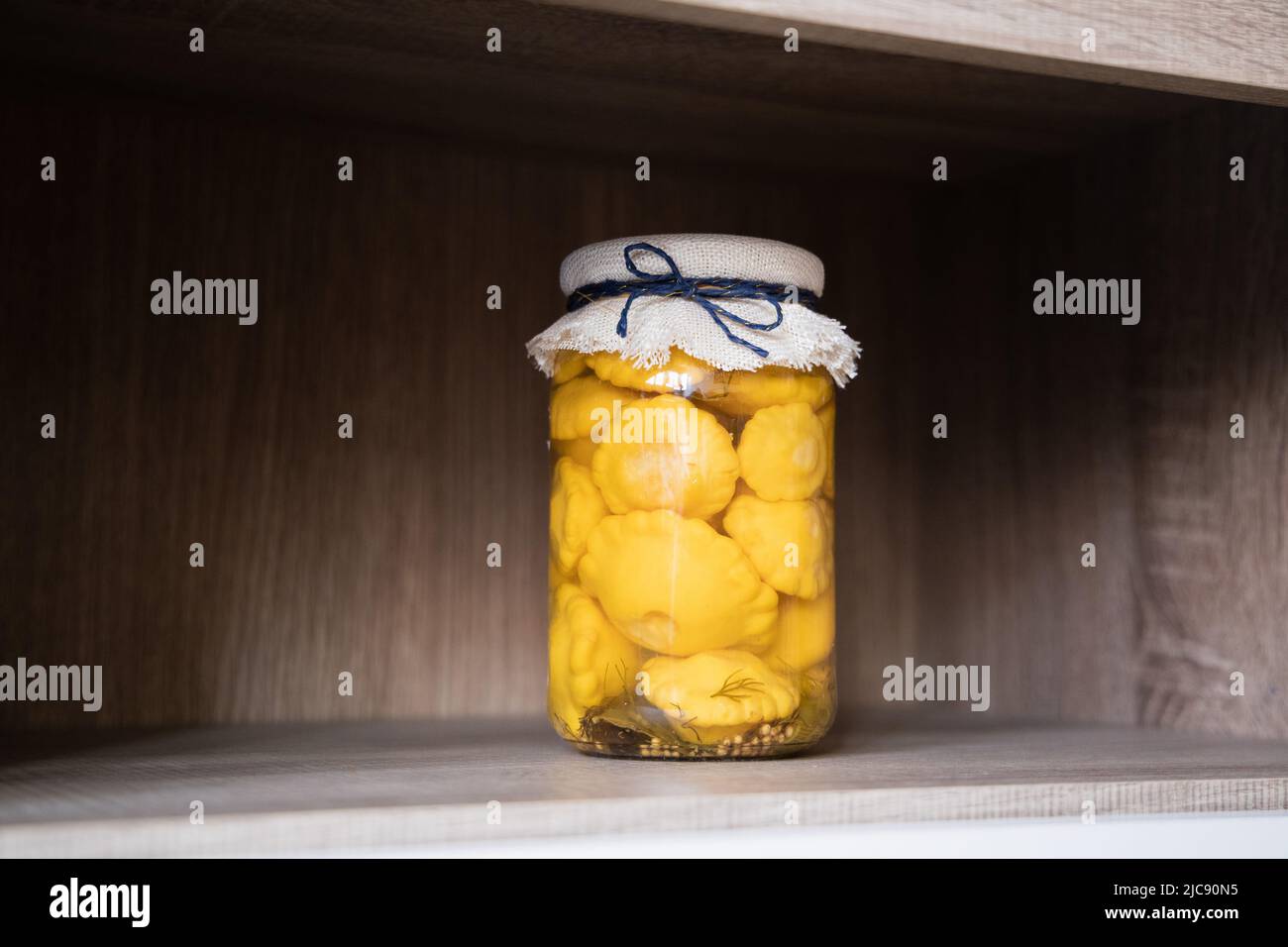 Glas mit mariniertem gelben Jakobsmuschel-Squash, hausgemachtem eingelegten Pattypan-Squash, konserviert Stockfoto