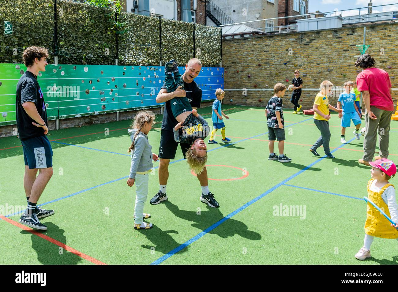 London, Großbritannien. 11.. Juni 2022. Freiwillige spielen mit den Kindern - Familes4Peace begrüßt ukrainische Mütter und Kinder aus ganz Nordwest-London in der Cavendish School in Camden. Referenten geben praktische Informationen über den Zugang zu Dienstleistungen, Umzugsberatung und Jobs, während Kinder spielen, unterstützt durch Freiwillige. Sie profitieren davon, dass sie sich in der gleichen Situation mit anderen zusammentun und hoffentlich dazu beitragen, das Trauma eines Umzugerichts in ein neues Land zu verringern, während sie Familienmitglieder zurücklassen, um Unsicherheit und Gefahr zu sehen. ‘London steht mit der Ukraine'. Kredit: Guy Bell/Alamy Live Nachrichten Stockfoto