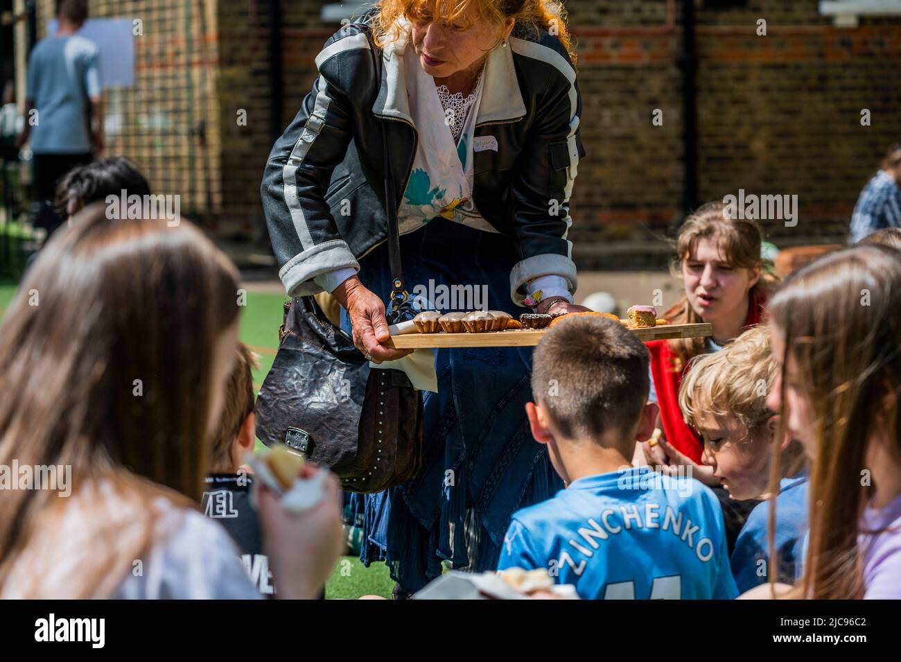 London, Großbritannien. 11.. Juni 2022. Ein Junge feiert seinen 7.. Geburtstag mit Kuchen für die Gruppe - Familes4Peace begrüßt ukrainische Mütter und Kinder aus ganz Nordwest-London an der Cavendish School in Camden. Referenten geben praktische Informationen über den Zugang zu Dienstleistungen, Umzugsberatung und Jobs, während Kinder spielen, unterstützt durch Freiwillige. Sie profitieren davon, dass sie sich in der gleichen Situation mit anderen zusammentun und hoffentlich dazu beitragen, das Trauma eines Umzugerichts in ein neues Land zu verringern, während sie Familienmitglieder zurücklassen, um Unsicherheit und Gefahr zu sehen. ‘London steht mit der Ukraine'. Kredit: Guy Bell/Alamy Live Nachrichten Stockfoto