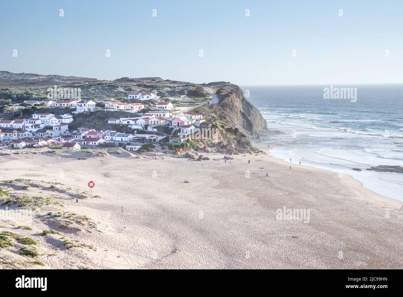 Die hübsche Stadt Praia de Monte Clérigo und der angrenzende Strand, der sich in der späten Nachmittagssonne sonnt - Algarve, Portugal Stockfoto